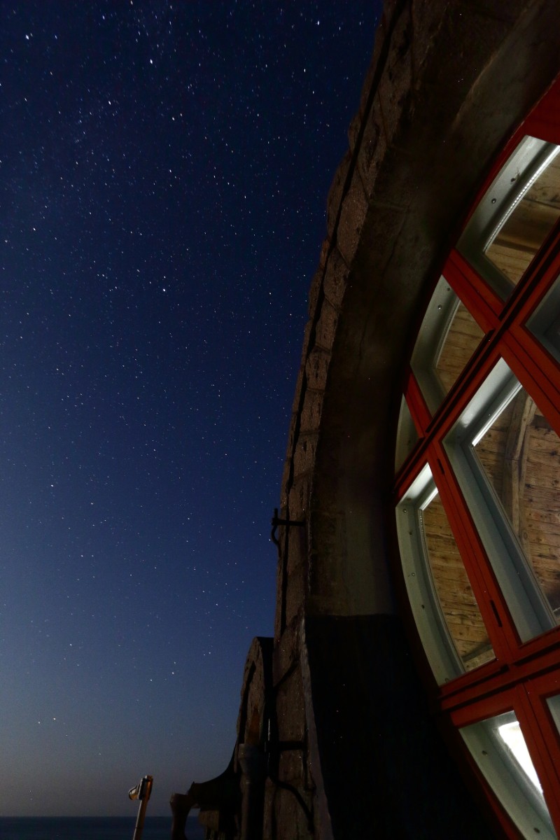 Foto av fyrens stora fönster på natten.